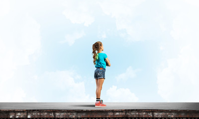 Concept of careless happy childhood with girl looking far away