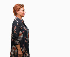 Atrractive senior caucasian redhead woman over isolated background looking to side, relax profile pose with natural face with confident smile.
