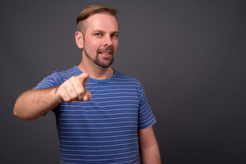 Blond bearded man with goatee against gray background