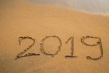 Abstract message Year 2019 written on beach sand