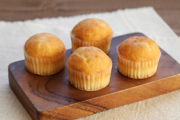 木のテーブルにのせた カップケーキ