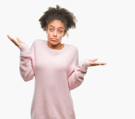 Young afro american woman wearing winter sweater over isolated background clueless and confused...
