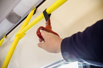 handrails in the cabin of a modern and comfortable city bus or electric bus. The hand is blurred