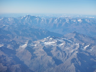 Obraz premium Flying over the European Alps during fall season. Landscape at the Mont Blanc and the glaciers. Aerial view from the airplane window