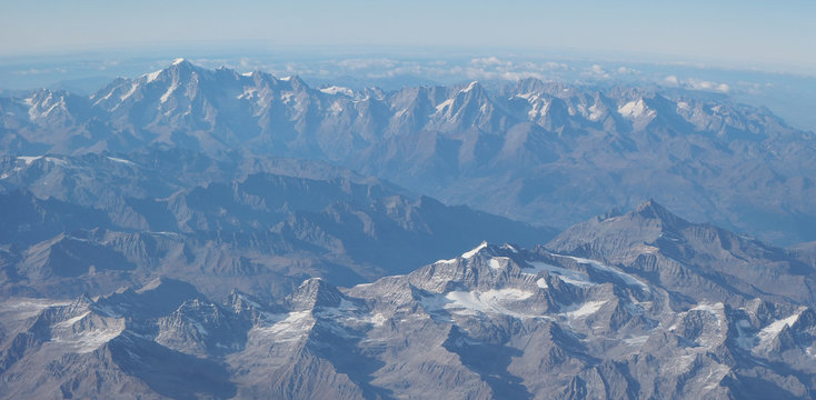 Fototapeta Flying over the European Alps during fall season. Landscape at the Mont Blanc and the glaciers. Aerial view from the airplane window