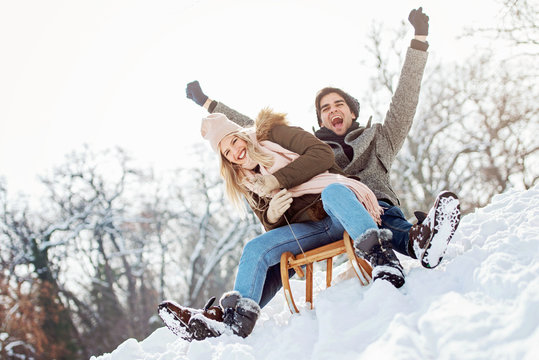 Two young people sliding on a sled 
