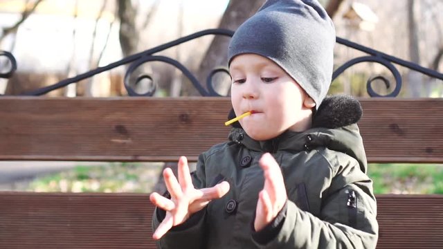 Little boy sucks (eats) green lollipop and enjoys