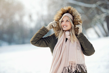Beautiful young woman enjoying in the snow