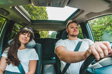 couple in car. tired driver. road trip