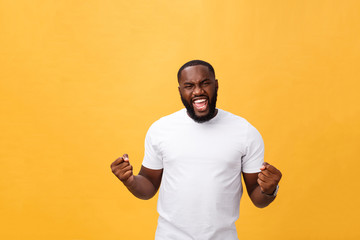 Handsome young Afro-American man employee feeling excited, gesturing actively, keeping fists clenched, exclaiming joyfully with mouth wide opened, happy with good luck or promotion at work