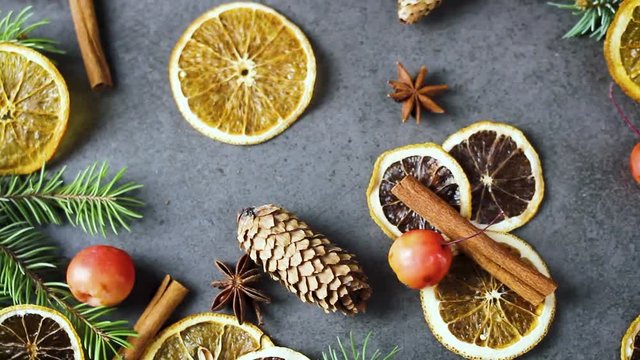Dried oranges with vanilla pine branches and other christmas decoration on dark surface. Close up.
