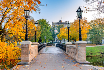 Central building of Latvian State University seen trough autumnal botanical public park of Riga, ...