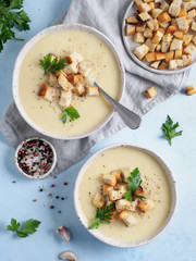 cauliflower potato soup puree on blue tabletop, Creamy cauliflower soup with toasted bread croutons. Vegetarian healthy food concept. Ideas and recipes for winter meal. Top view or flat lay
