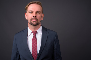 Blond bearded businessman with goatee against gray background