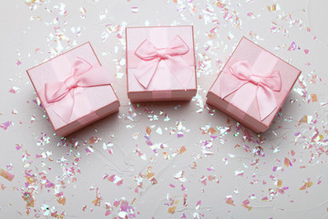 Christmas gifts with pink ribbon on white background with festive decorations. Christmas background with copy space.