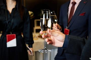 Hands holding the glasses of champagne making a toast conversation negotiation business concept