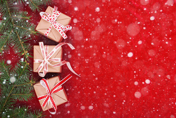 Christmas gifts with red ribbon on red background with decorations. Christmas background with copy space.