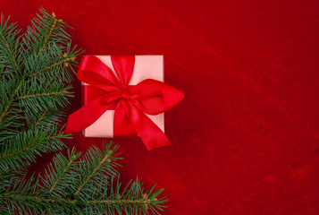 Christmas gifts with red ribbon on red background with decorations. Christmas background with copy space.