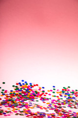 Fototapeta na wymiar colorful confetti on pinkn background
