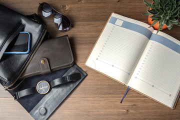 Business accessories on desktop: notebook, bag, watch, pen, cufflink and phone. Success in business.