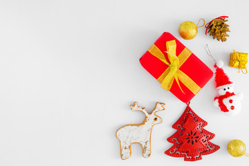 Christmas composition. Christmas gift boxes, red fir tree, snowman, reindeer, gold balls and pine cone on white background. Creative flat lay, border and copy space