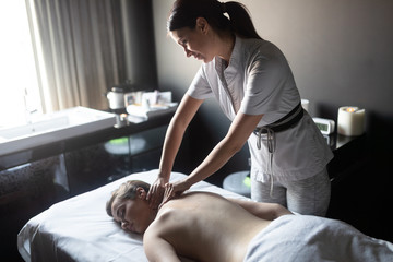 Young woman enjoying massage in spa salon