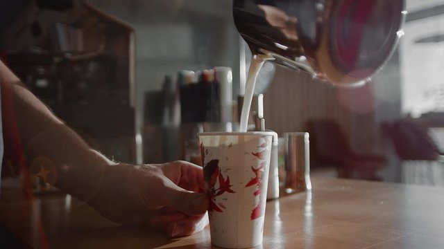 A man pours milk into a glass. Making coffee with you. Hands in sunlight close-up. 4K