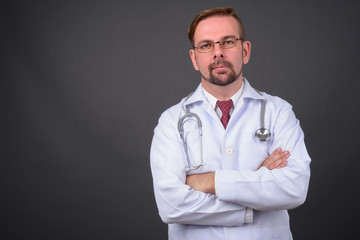 Blond bearded man doctor with goatee against gray background