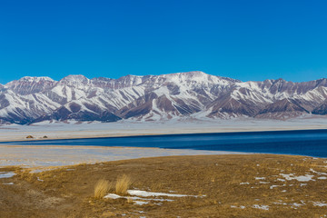   The frozen Sailimu lake with snow mountain background at Yili, Xinjiang of China