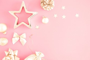 Christmas composition. Xmas gold decorations on pastel pink background. Flat lay, top view, copy space 