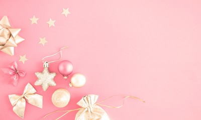 Christmas composition. Xmas gold decorations on pastel pink background. Flat lay, top view, copy space 