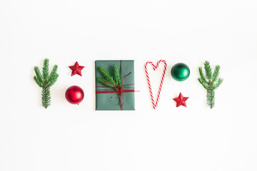 Christmas composition. Postcard, fir tree branches, red and green decorations on white background. Christmas, winter, new year concept. Flat lay, top view