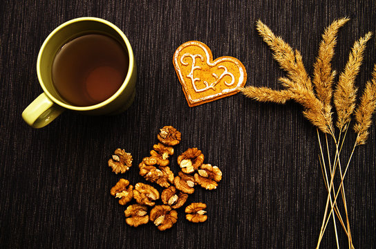 a Cup of green tea, walnuts and gingerbread on a dark background © Julia