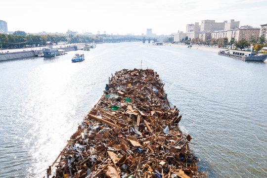 barge with trash floats down the river