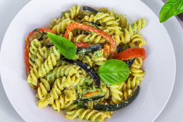 Italian pasta - fusilli with eggplants, tomatoes and pesto sauce.