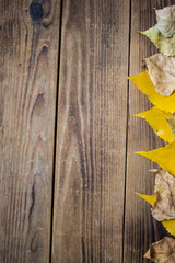 background autumn yellow leaves on wooden background