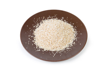 Uncooked fine-ground barley groat on the brown dish