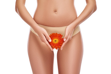 Beautiful woman is showing her thigh with flower. Cropped photo