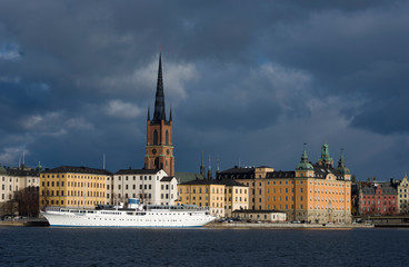 Naklejka premium Water view over Stockholm an late autumn day, snowy, sun and clear sky over boats and landmarks