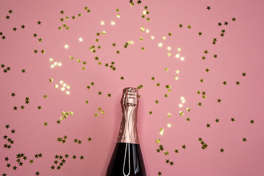 champagne bottle and confetti, flat lay, copy space