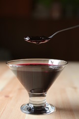 Glass vase with dark red jam