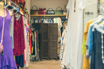 Female legs under wooden folding screen in the store with clothes