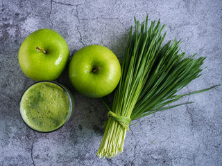 Detox juice mix between wheat grass and apple on top view. Nutrition food concept. Healthy drinking.