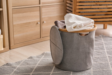 Laundry basket with dirty towels on floor in bathroom