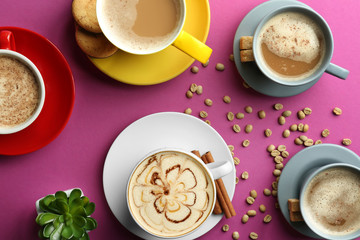 Many cups with tasty aromatic coffee on color background, flat lay