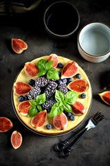Homemade delicious cheesecake with fresh figs and frozen blueberries and blackberries. Healthy baking in multicooker