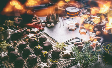 Homemade chocolate praline on dark table with nuts, marshmallows and cinnamon star Christmas cookies. Home holidays cuisine and sweet gifts making. Christmas food. Cozy festive homely atmosphere