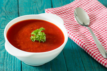 Creamy tomato soup  on blue wooden kitchen table 