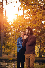 Couple in autumn season colored park enjoying outdoors.