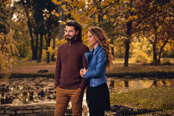 Naklejka premium Couple in autumn season colored park enjoying outdoors.